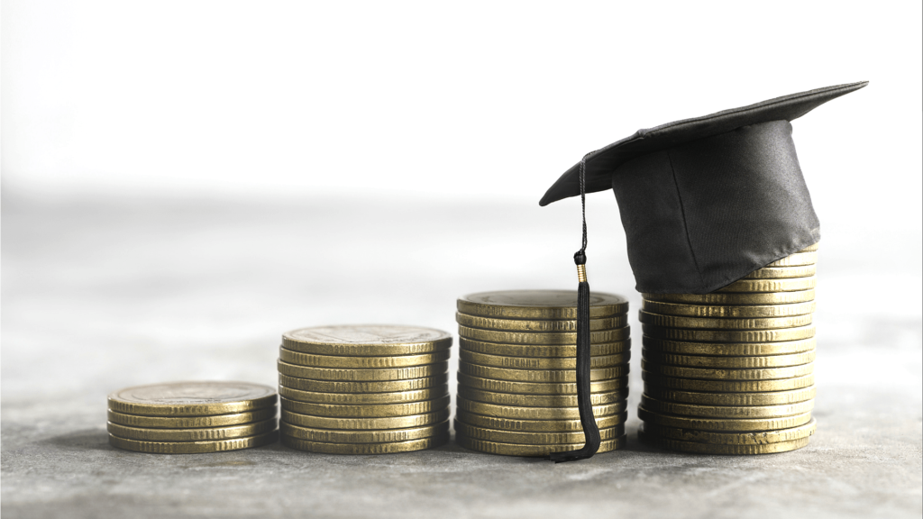 Photo d'une pile de monnaie, la dernière colonne ayant un chapeau de graduation